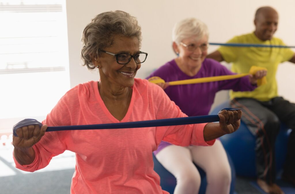 Older adults participating in a resistance band exercise class, smiling and enjoying the workout.